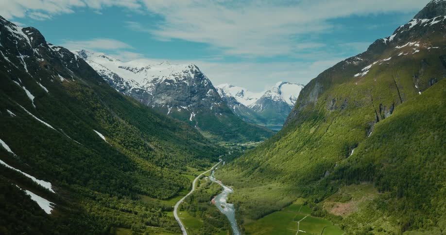 A trail runs along the stream between the mountains