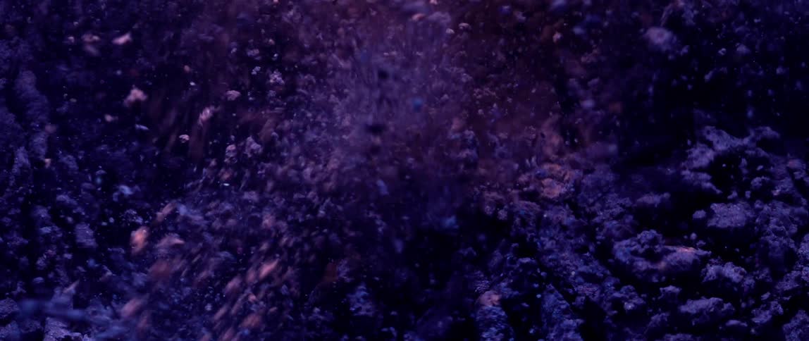 Purple powder particles in abstract motion