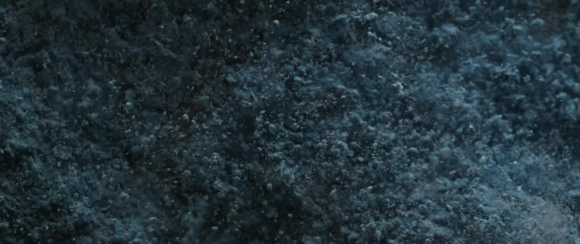 A closeup of fine powdery dust particles blasting up over a vibrating surface