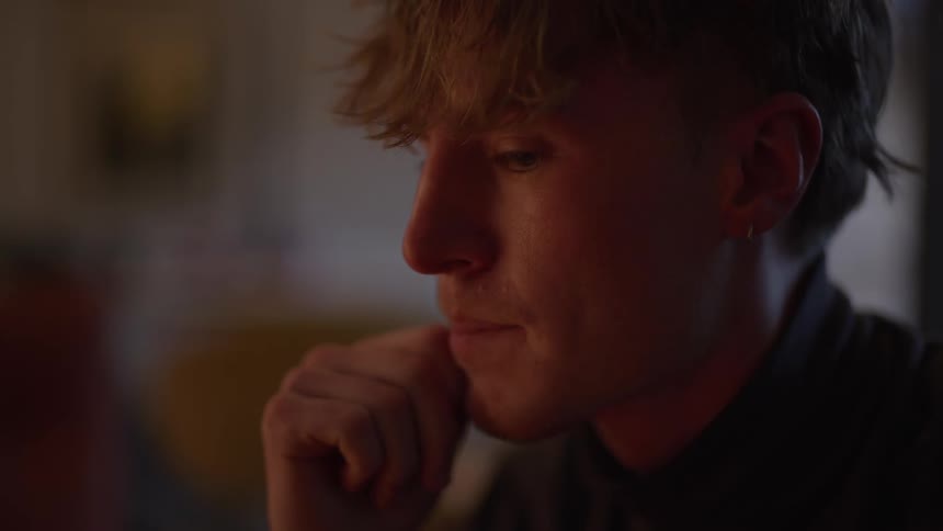A man moves his fingers on his mouth as he thinks