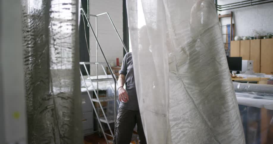 Two tailors talk while looking over fabric