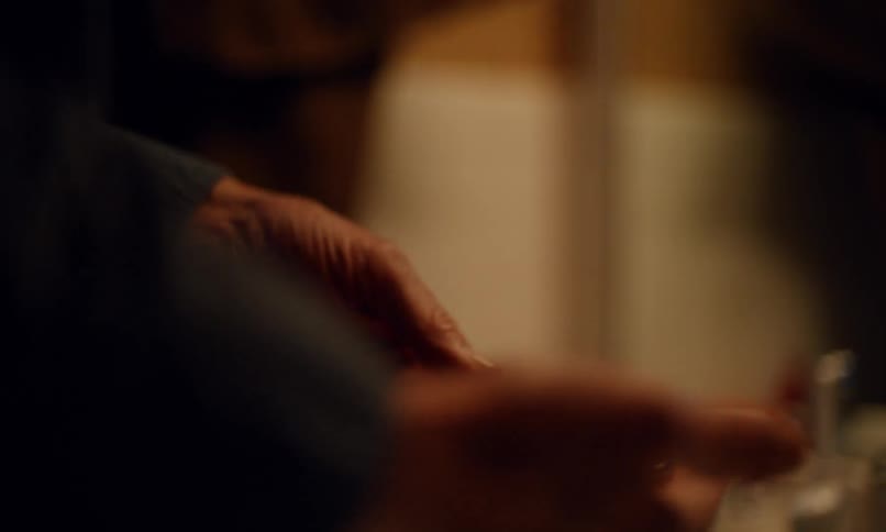 Pair of hands of an elderly person taking off his own wedding ring