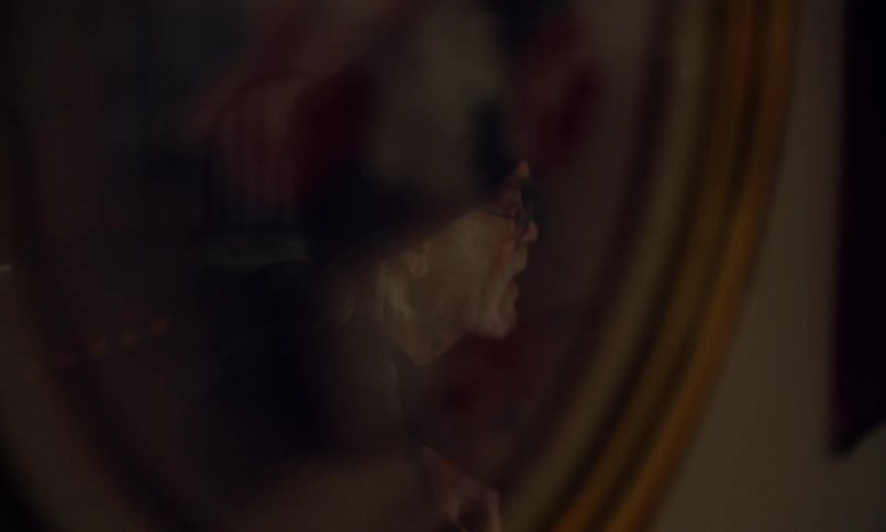 Reflection of an elderly man talking