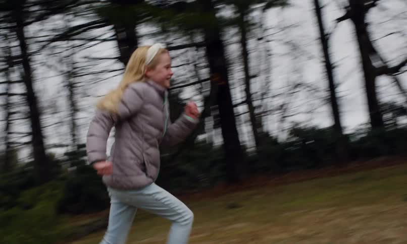 Two kids running around a backyard having fun