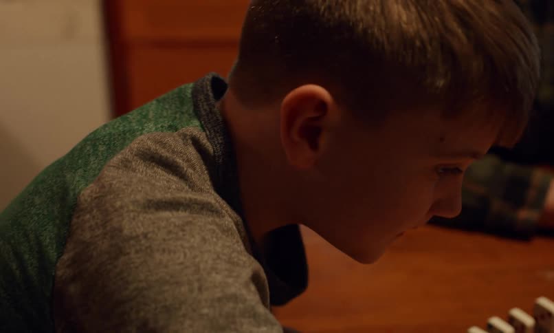 A couple of children are playing with dominoes on a table at home