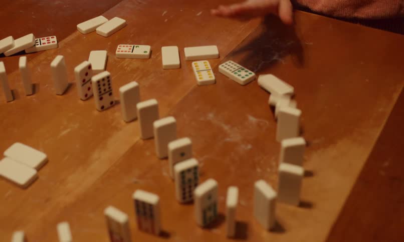 A family is playing with dominoes at a table