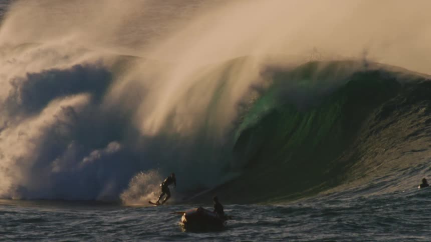 Surfer dropping into a tubular wave