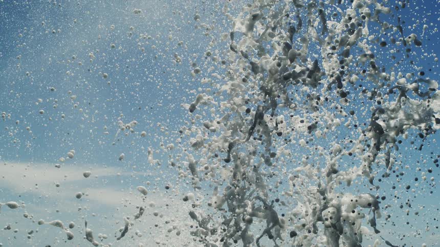 Foam jet with water rising and falling against a blue sky