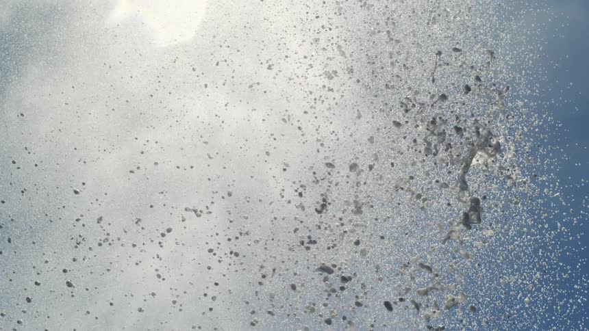 Column of water and steam being expelled with force against the blue sky forming a dense cloud of droplets