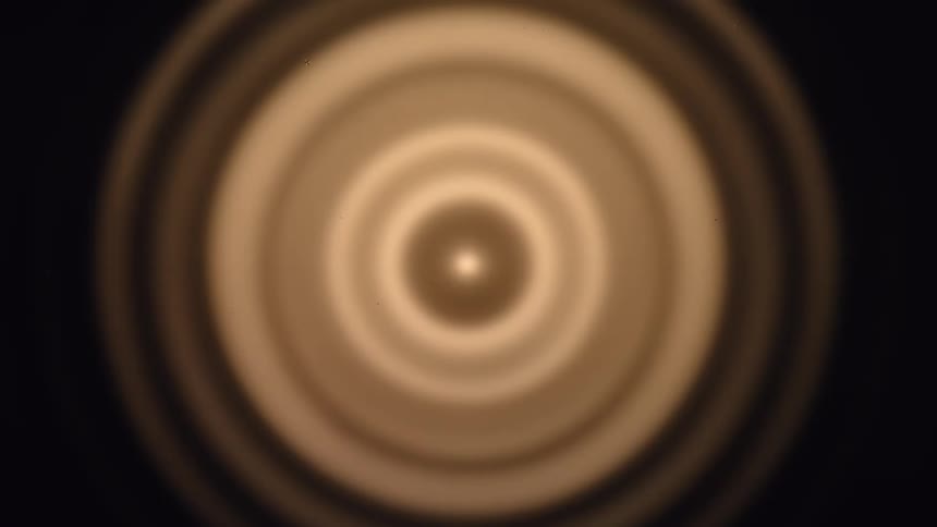 An orange colored object is blurred and rotating rapidly