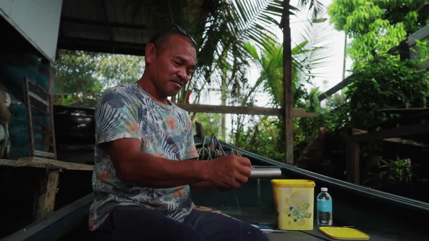 Fisherman sitting and reeling in a fishing line