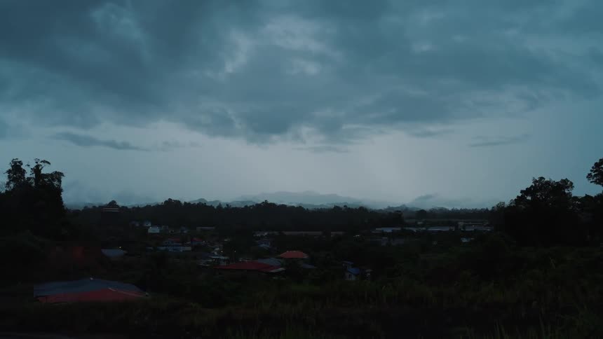 Landscape of a rural area surrounded by silhouettes of forests