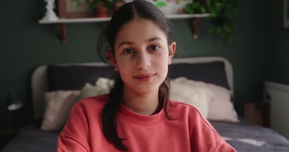 Girl in pink blouse sitting writing