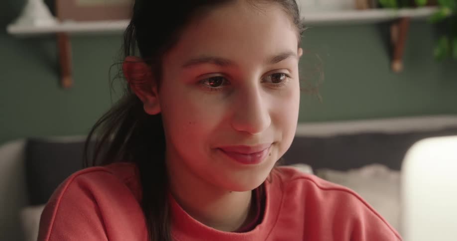 Portrait of a happy girl interacting with a laptop and in front of her