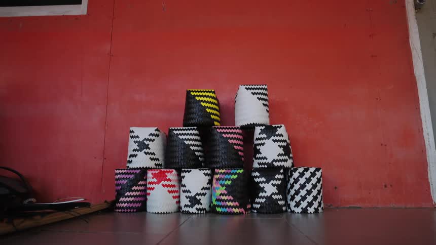 Several white buckets with design details stacked next to a red wall