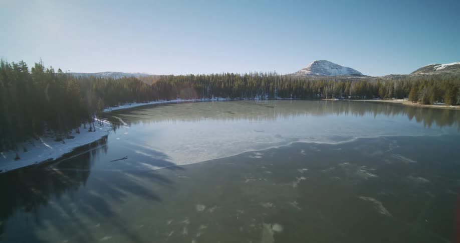 A river winds through a forestnear the mountains