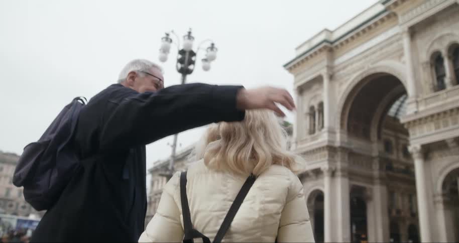 Couple hugging together while walking through a classic city