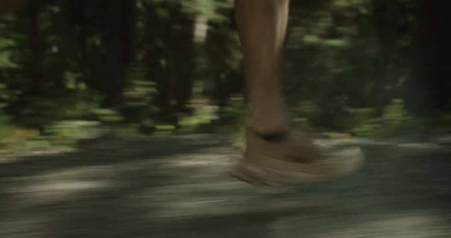 A person is running on a dirt trail in the forest