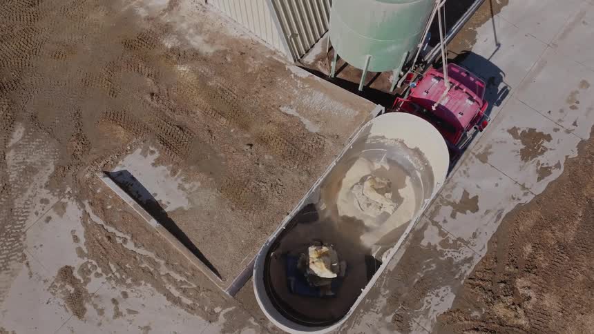 Vehicle drives past a slurry being mixed in a large outdoor tub