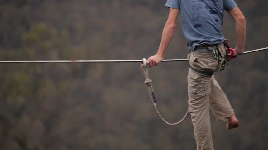 Man slides on a tightrope