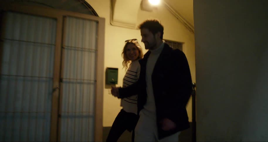 Happy couple walking hand in hand down a hallway