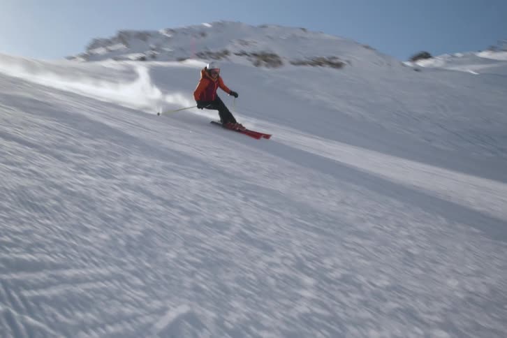 A man skis down the bright white slope