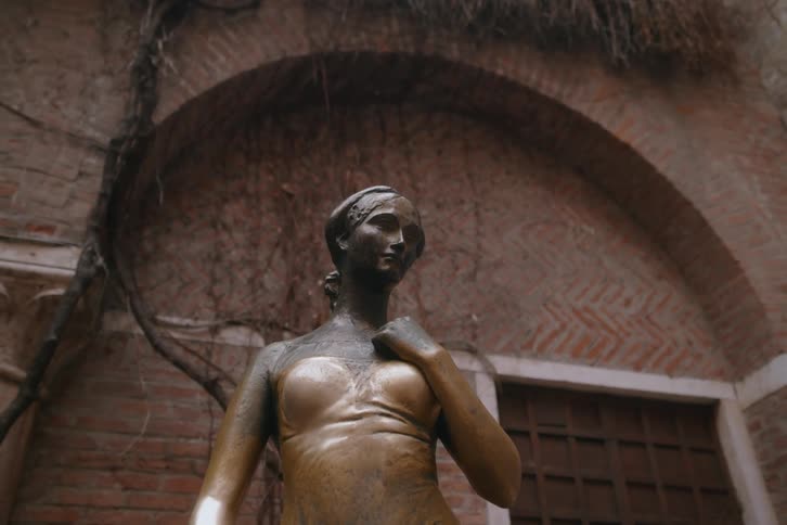 A bronze statue of a woman is in front of the building