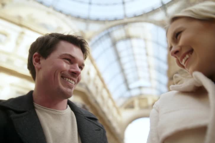 A couple of a man and a woman who are kissing and then they look at each other happily