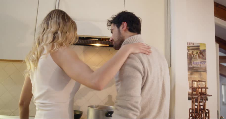 A couple is together in the kitchen