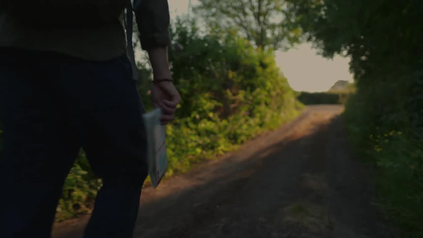 A man is walking on a trail on a cloudy day