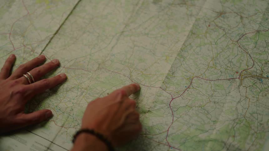 A footage of a persons hand reading a map