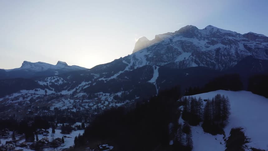 Snowy mountains and conifers at dawn