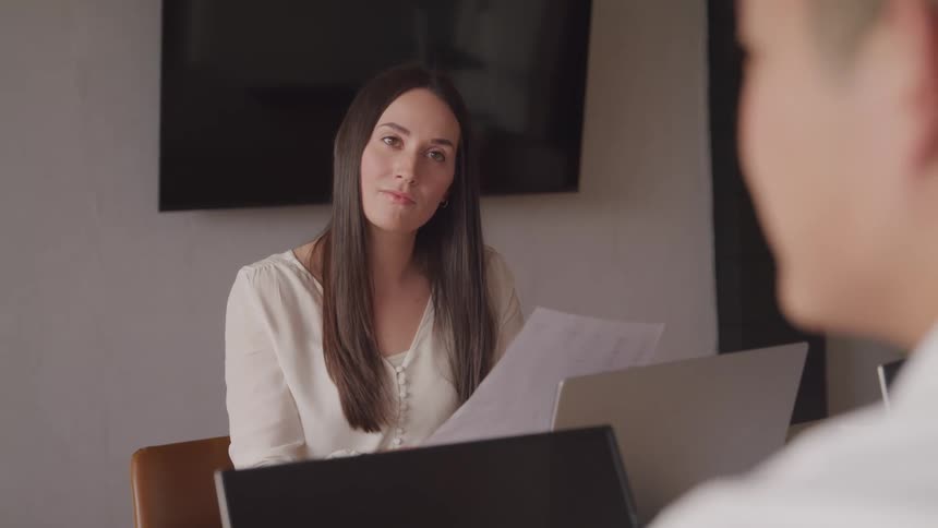 The face of a woman who is looking straight ahead where there is a person talking to her