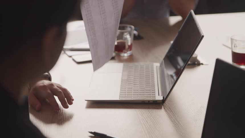 A footage of people sharing hardcopy documents in a meeting