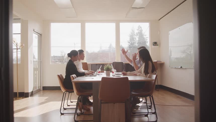 Office worker gestures while explaining during a office meeting