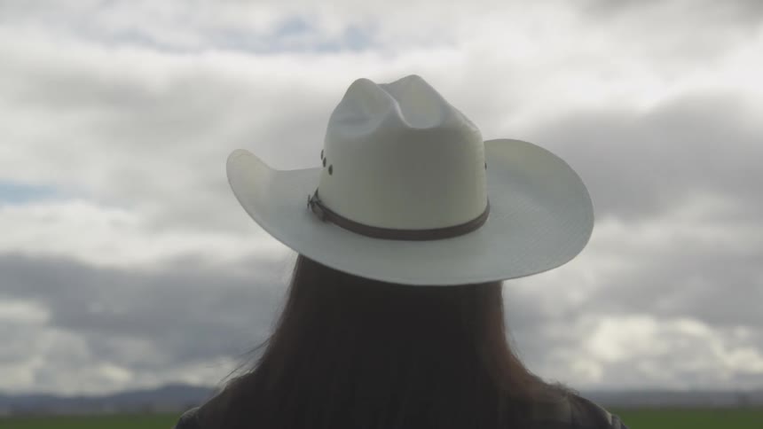 A close up back clip of a lady wearing a cowboy hat