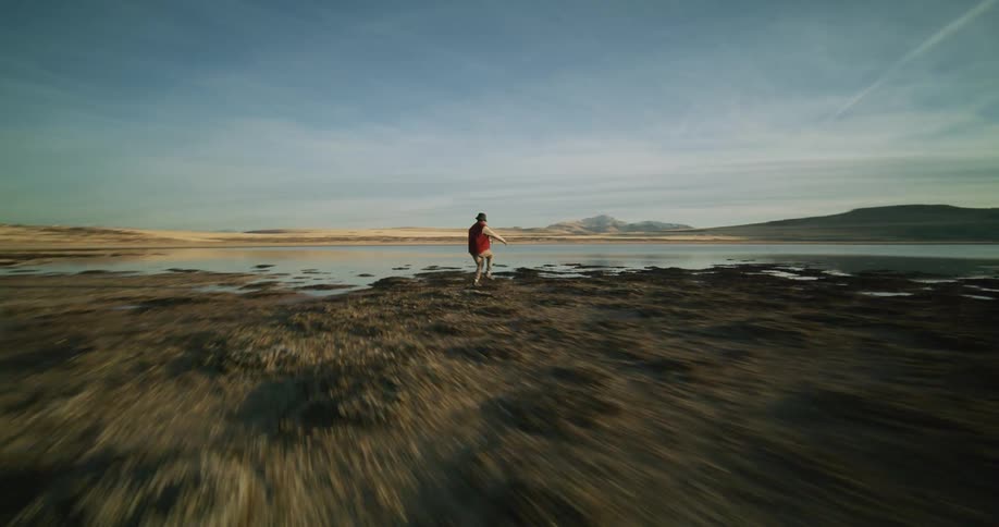 A man is doing a creative dance on the beach