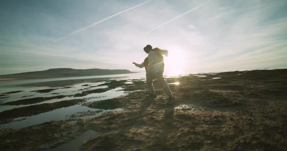 A man is dancing on a coastal beach