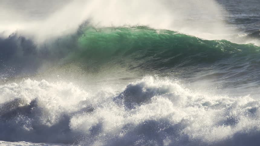 Green ocean water forms large swelling and cresting waves during the day