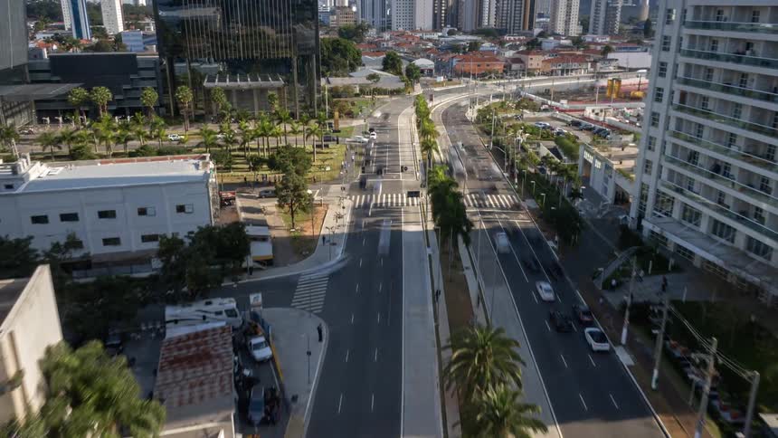 An aerial view of a large twoway highway in a city with several tall buildings