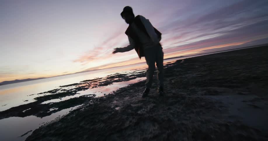 A man is dancing as the sun rises