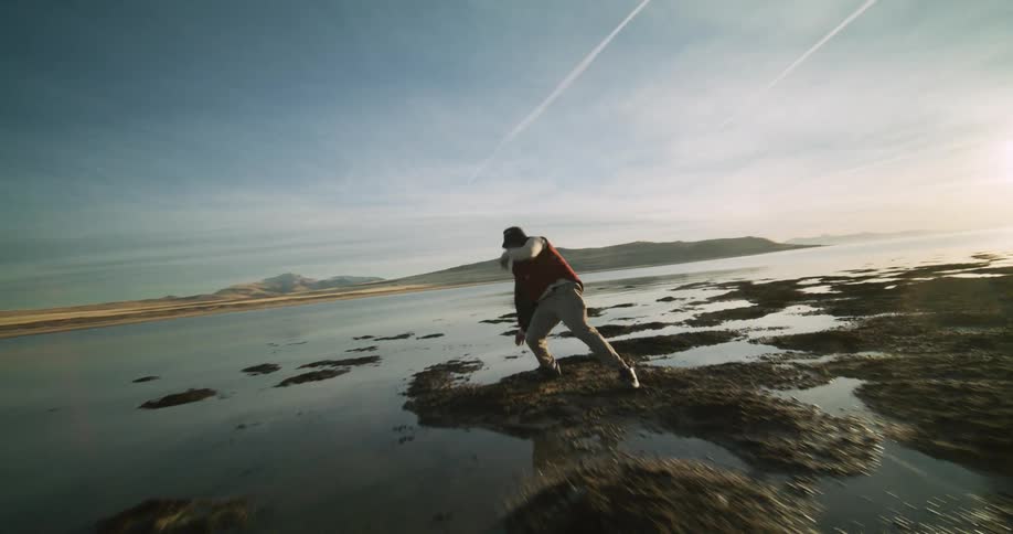 A man is breakdancing right by the water