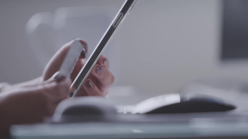 A persons fingers typing on a cell phone screen