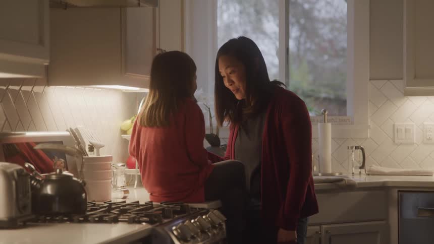 A mother is talking with her daughter in the kitchen