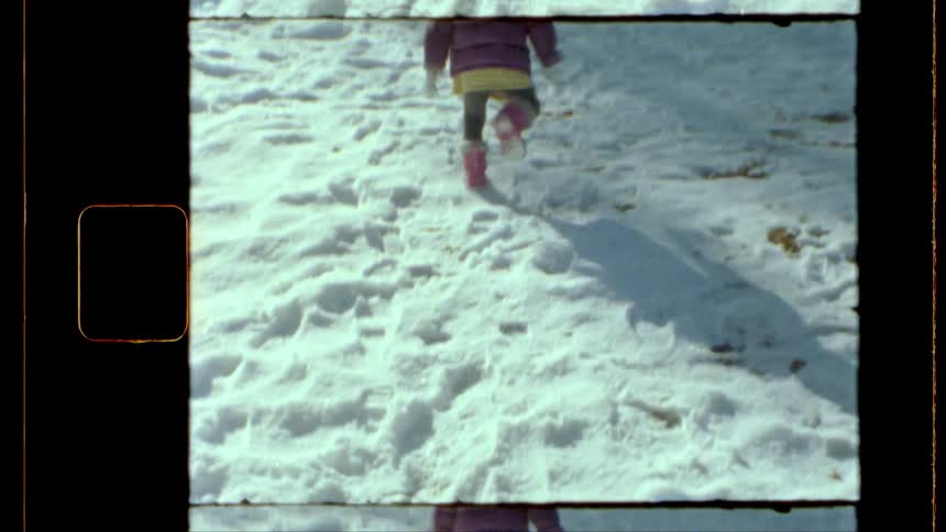 Archival footage small child in red jacket and orange boots running in the snow