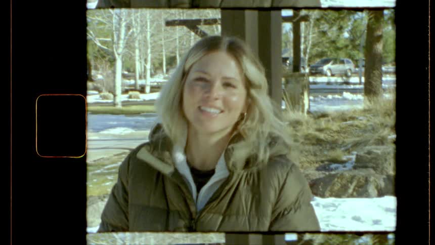 Smiling blonde woman standing in a snowy area in daylight