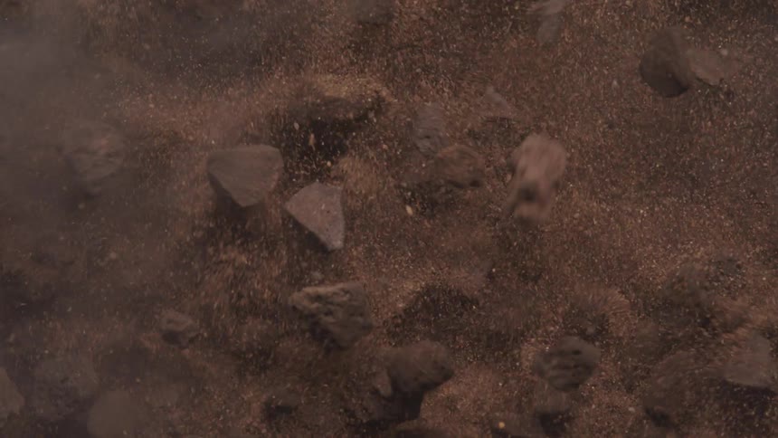 A closeup view of a shaking surface shows scattered rocks and debris bouncing around