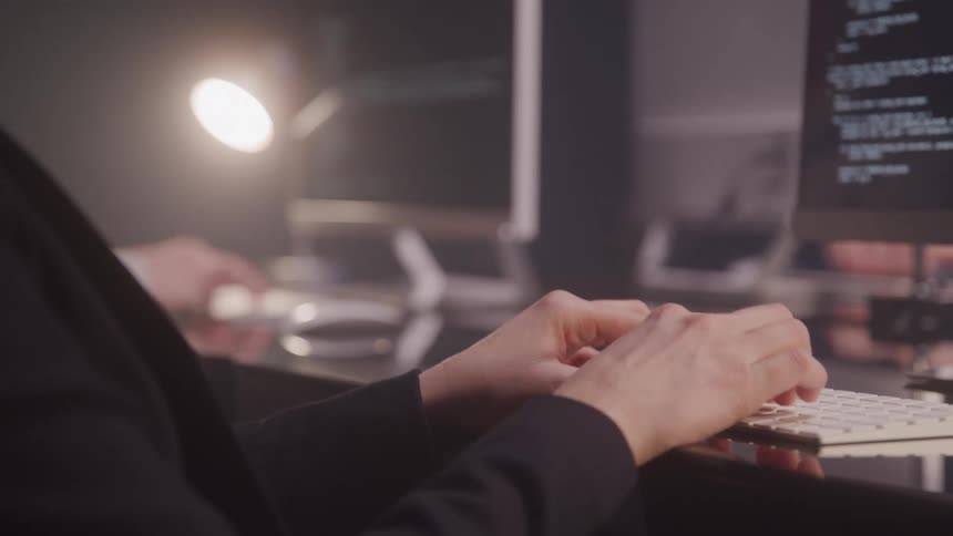 Three people are working in the office and typing on a computer