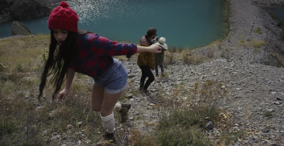 Three people are hiking up  steep hill