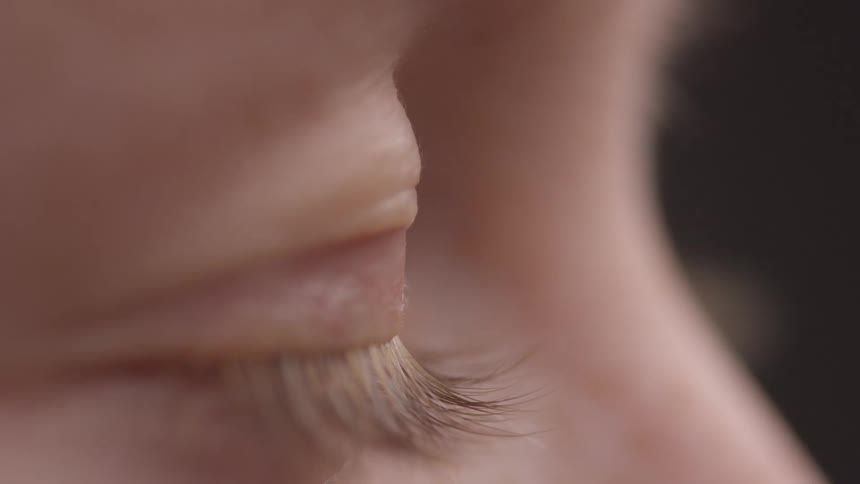 Side closeup of a persons eye blinking